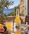 Bouteille et verre Sevenne Mangue Figuier, boisson pétillante sans alcool, avec mangue et figues fraîches sur une terrasse méditerranéenne